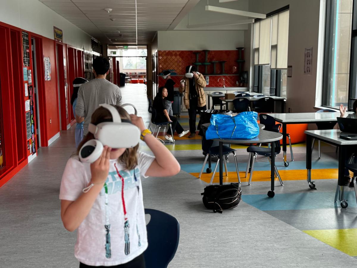 A student puts on a VR headset in a school hallway